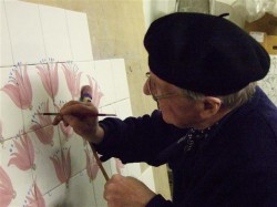 Rye Pottery's creative and design director Tarquin Cole painting Rye Tile mural